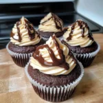 Chocolate coffee cream cupcakes with chocolate buttercream frosting, white and dark chocolate drizzle, and a coffee cream filling inside a moist chocolate cake base
