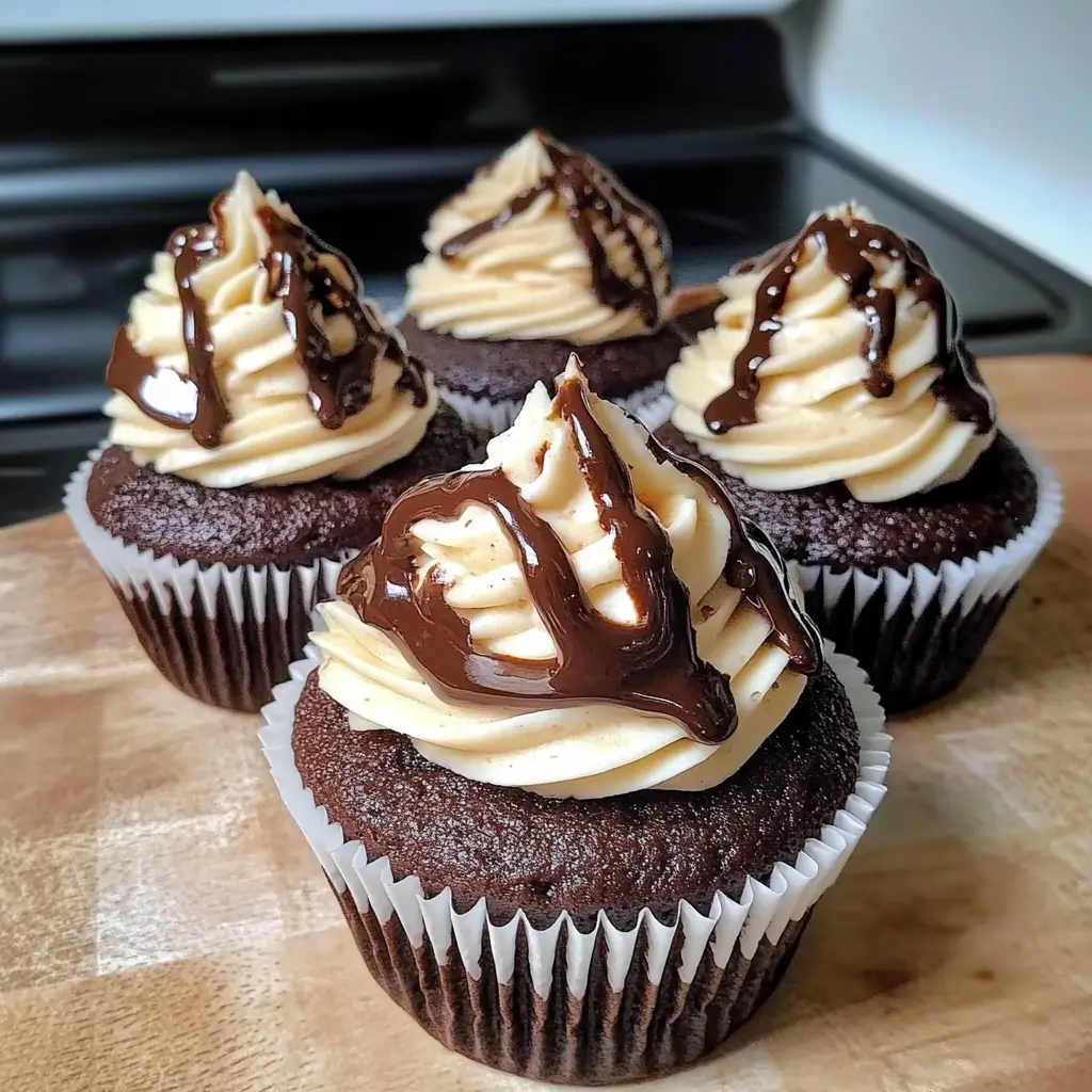 Chocolate coffee cream cupcakes with chocolate buttercream frosting, white and dark chocolate drizzle, and a coffee cream filling inside a moist chocolate cake base